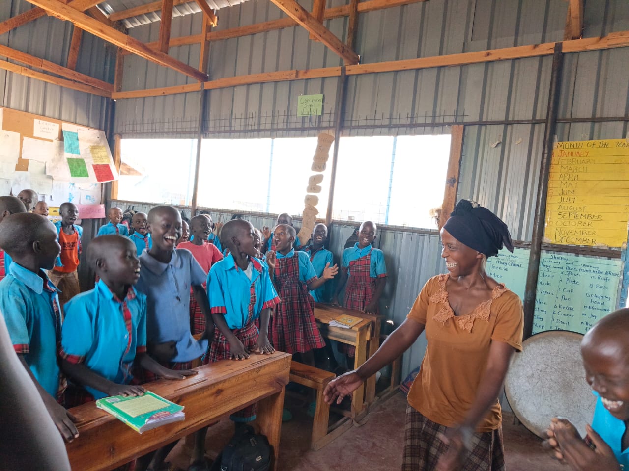 A parent actively participating in a Light Academy classroom activity in Kalobeyei, Kenya